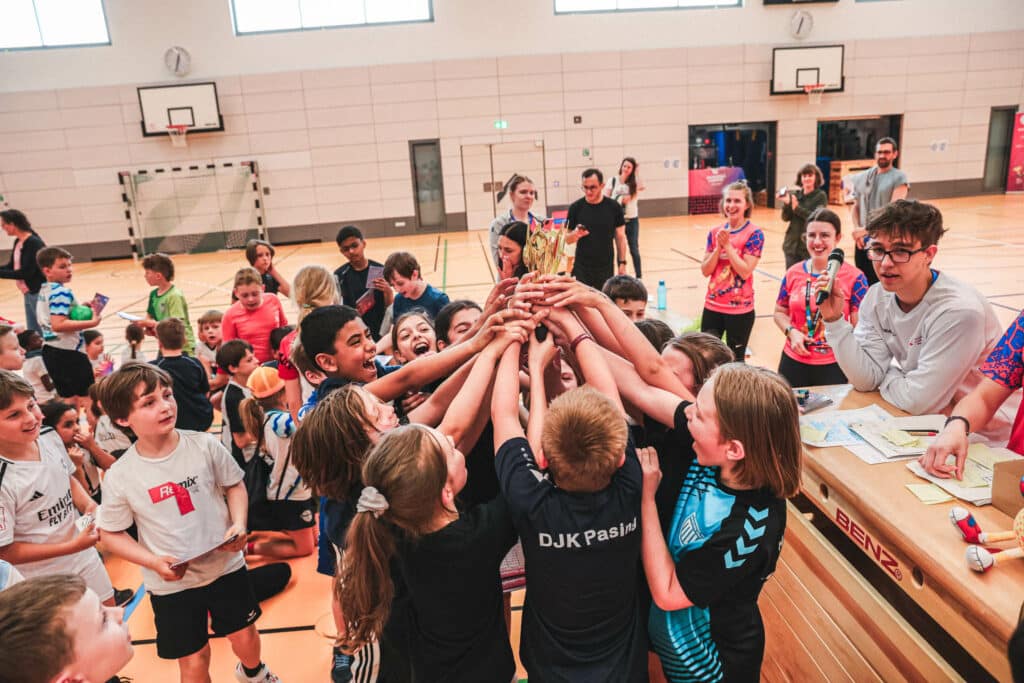 Kinder jubeln mit ihrem gewonnenem Pokal